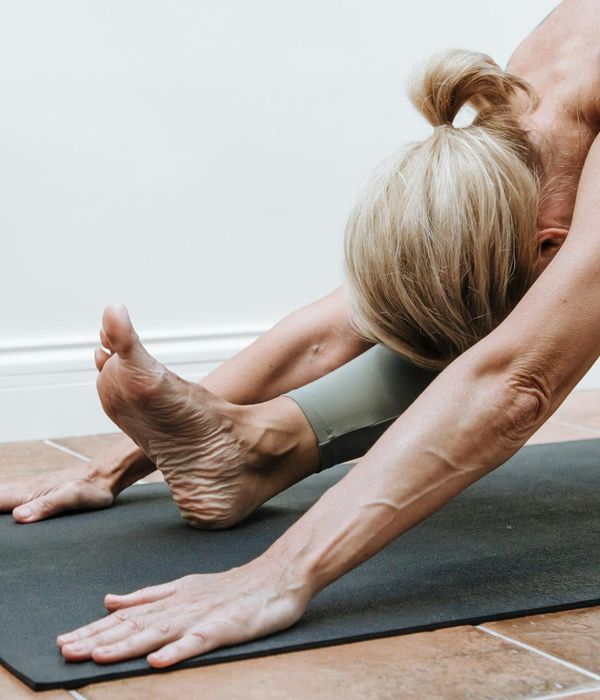 Woman in a calm yoga pose, embodying peace and balance in a light-filled room.
